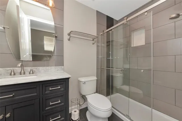 a bathroom with a granite countertop toilet sink and shower