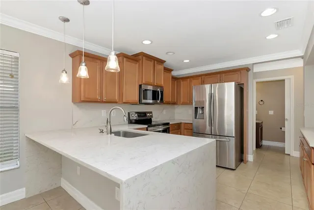 a kitchen with stainless steel appliances a refrigerator sink and microwave
