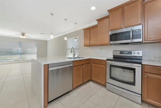 a kitchen with stainless steel appliances granite countertop a sink dishwasher a stove and a microwave oven with cabinets
