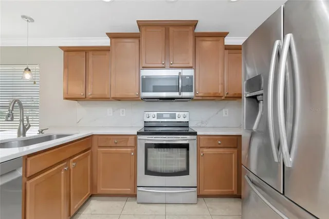 a kitchen with stainless steel appliances granite countertop a stove a refrigerator and a sink