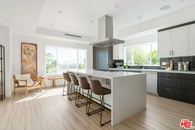 a kitchen with a table chairs a sink dishwasher window and cabinets