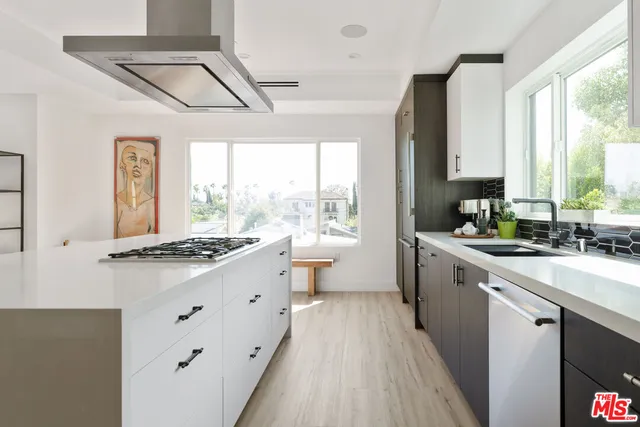 a kitchen with granite countertop a sink appliances cabinets and a large window