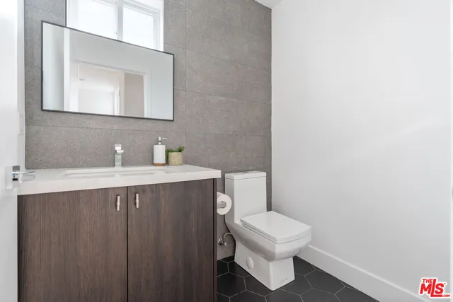 a bathroom with a toilet a sink and mirror