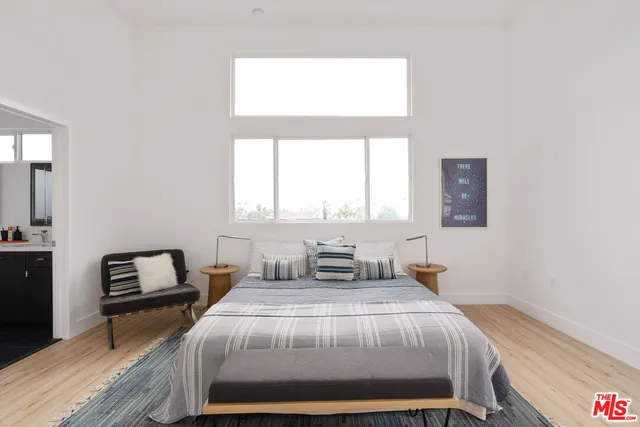 a bedroom with a bed and wooden floor