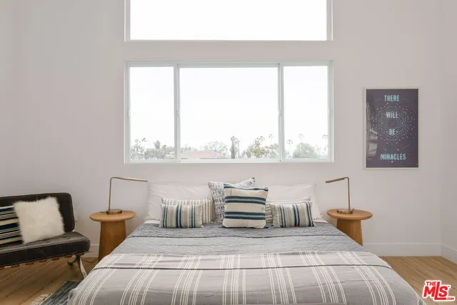 a bedroom with a bed a couch and a window