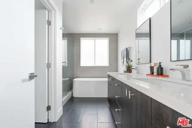 a bathroom with a tub sink and mirror