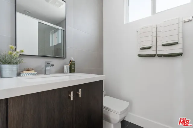 a bathroom with a sink a toilet and a mirror