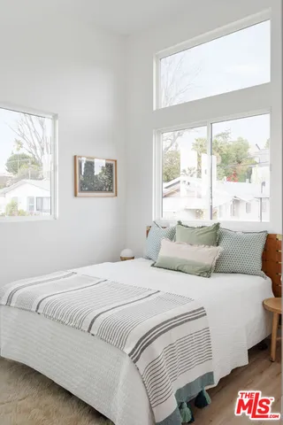 a bedroom with a bed and a large window