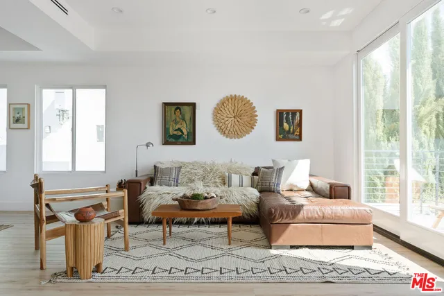 a living room with furniture a rug and a large window