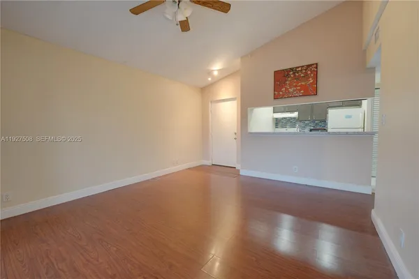 a view of an empty room with wooden floor