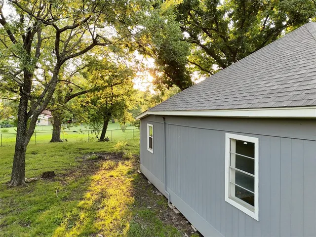 a yellow house with trees in front of it