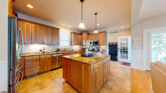 a kitchen with stainless steel appliances granite countertop a sink a stove and a refrigerator