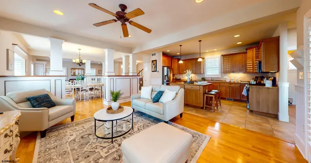 a living room with furniture kitchen view and a chandelier