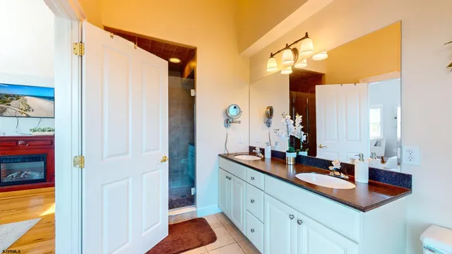 a view of a hallway with wooden floor and a bathroom