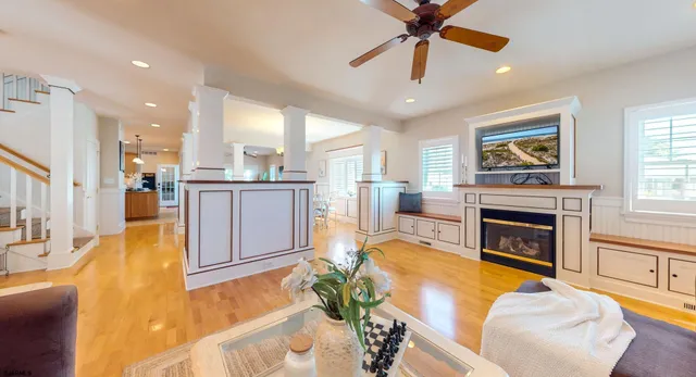 a living room with stainless steel appliances furniture windows and a fireplace