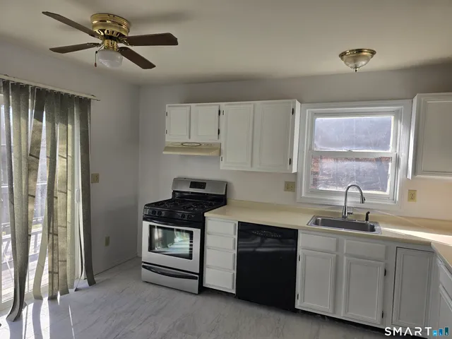 a kitchen with cabinets stainless steel appliances and a window