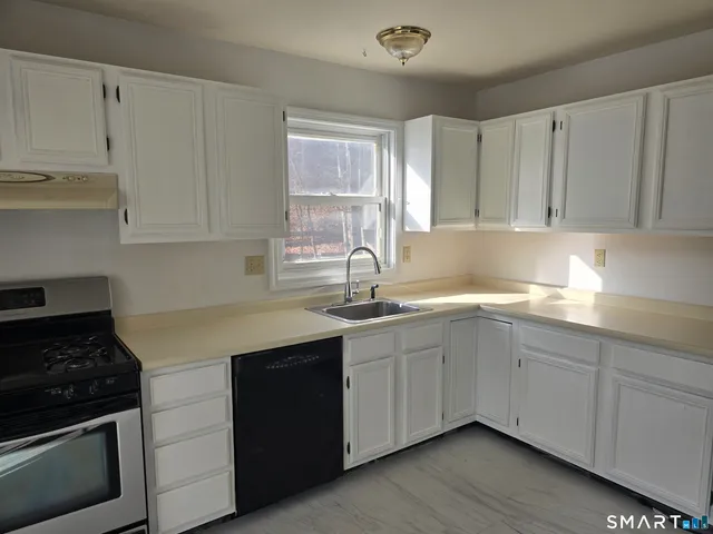a kitchen with stainless steel appliances granite countertop a sink stove and cabinets