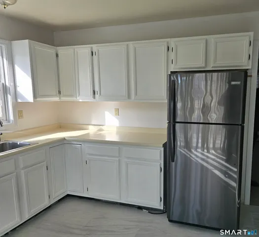 a kitchen with cabinets and a refrigerator