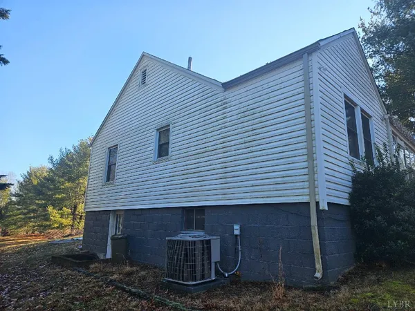 a view of a house with a yard and large tree