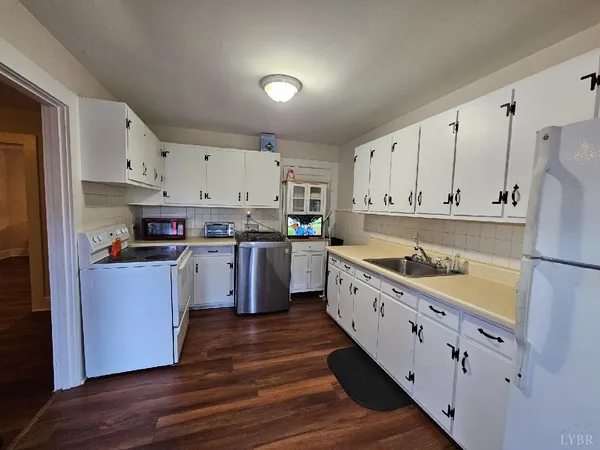 a kitchen with cabinets wooden floor and stainless steel appliances