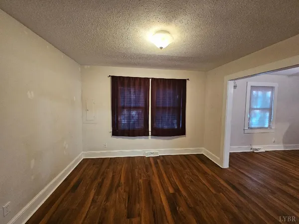 a view of a room with wooden floor a ceiling fan