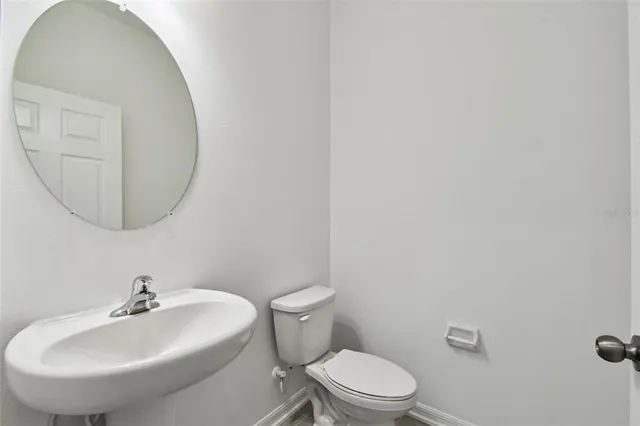a bathroom with a toilet a sink and mirror