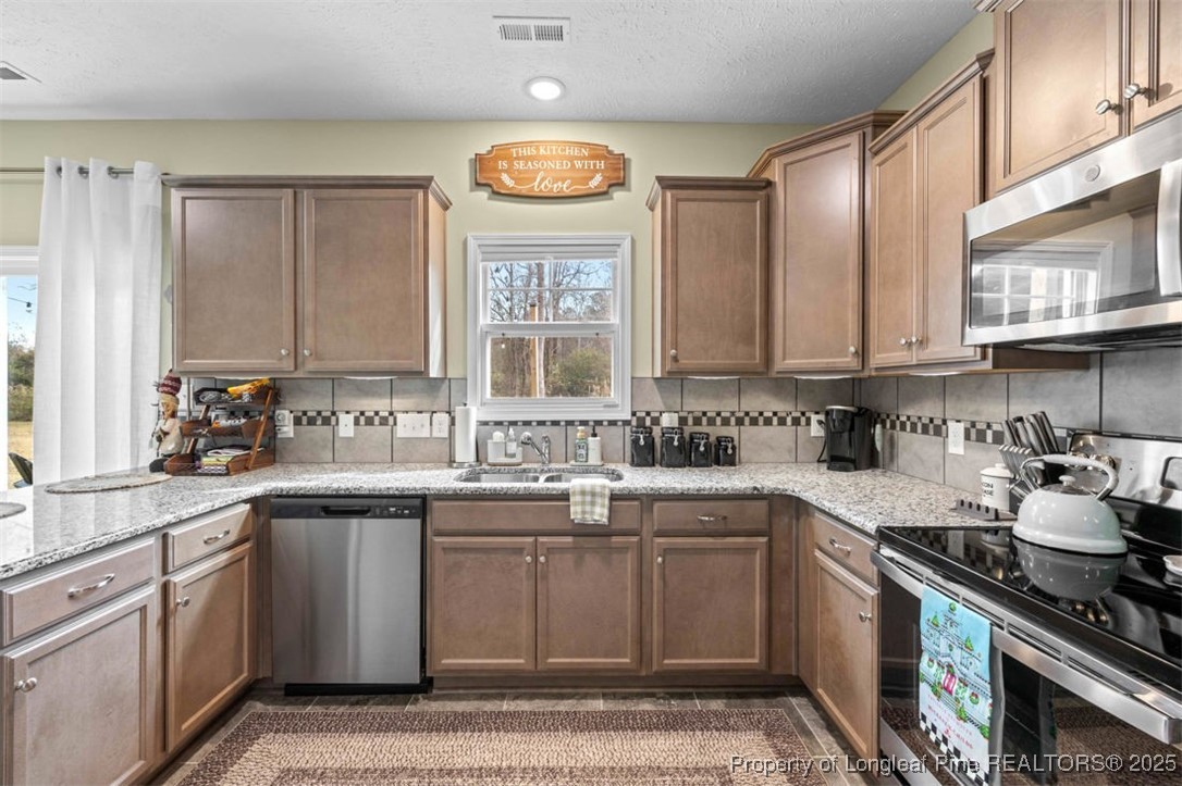 5512 Tolarsville Road St. Pauls, NC 28384 - Photo 11 of 30 a kitchen with stainless steel appliances granite countertop a sink a stove a cabinets and a window