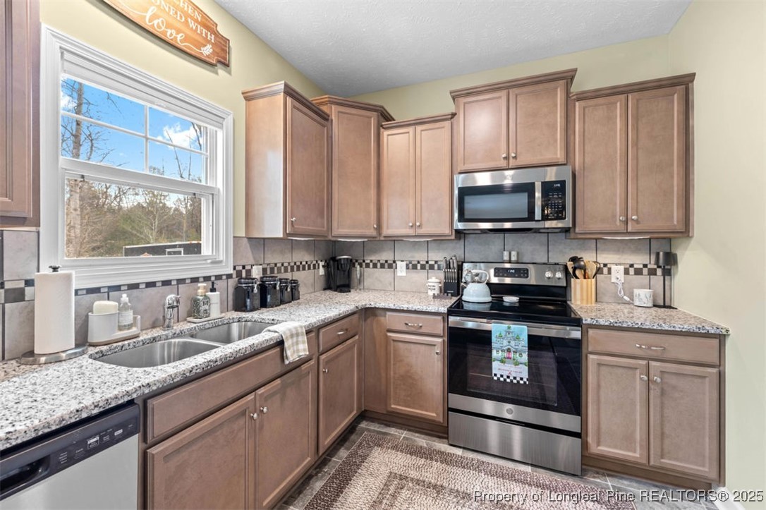5512 Tolarsville Road St. Pauls, NC 28384 - Photo 13 of 30 a kitchen with stainless steel appliances granite countertop a sink stove and microwave