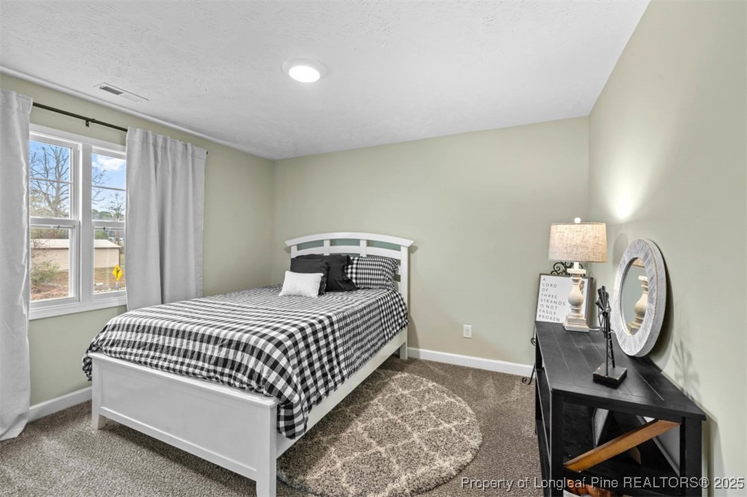 5512 Tolarsville Road St. Pauls, NC 28384 - Photo 19 of 30 a bedroom with a bed a clock on the dresser and a table