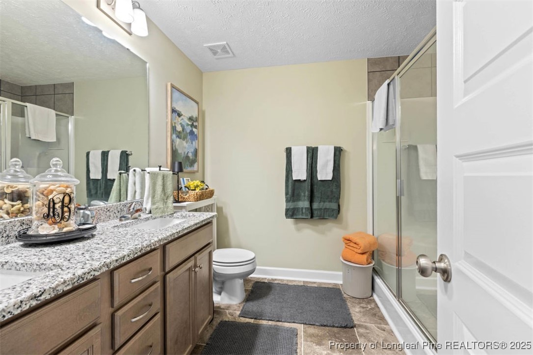 5512 Tolarsville Road St. Pauls, NC 28384 - Photo 22 of 30 a bathroom with a granite countertop sink a toilet and shower