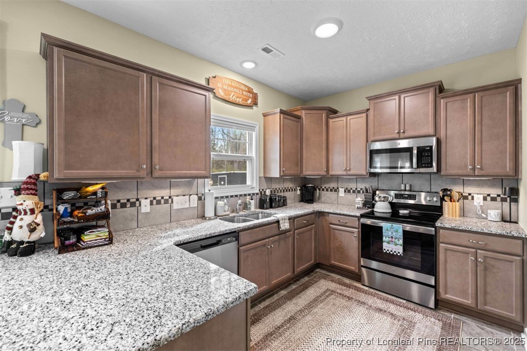 5512 Tolarsville Road St. Pauls, NC 28384 - Photo 10 of 30 a kitchen with stainless steel appliances granite countertop a sink stove and microwave