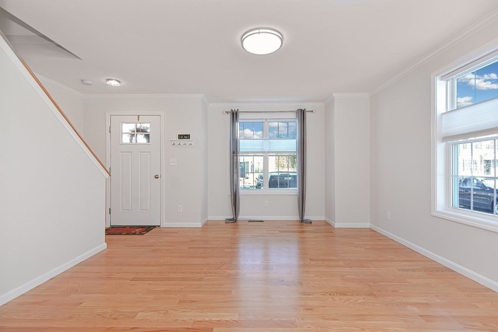 38 Riley Road, Unit 38 Tyngsboro, MA 01879 - Photo 7 of 25 a view of an empty room with wooden floor and a window
