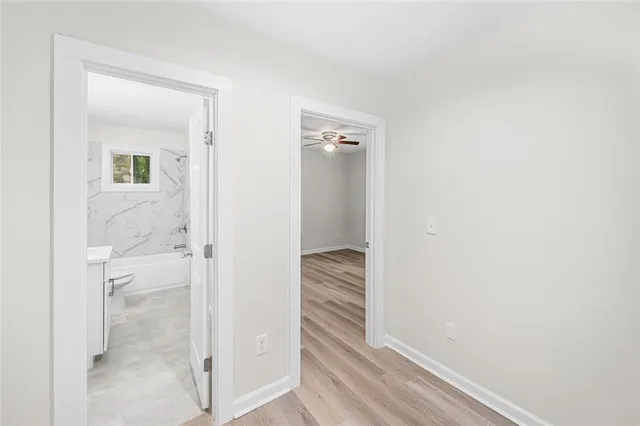 a view of a hallway with closet and bathroom