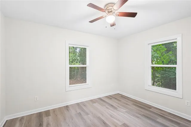 an empty room with a window and a fan