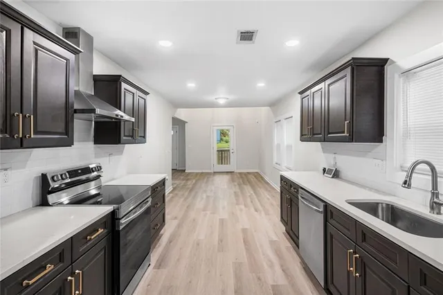 a kitchen with stainless steel appliances granite countertop a sink stove and refrigerator
