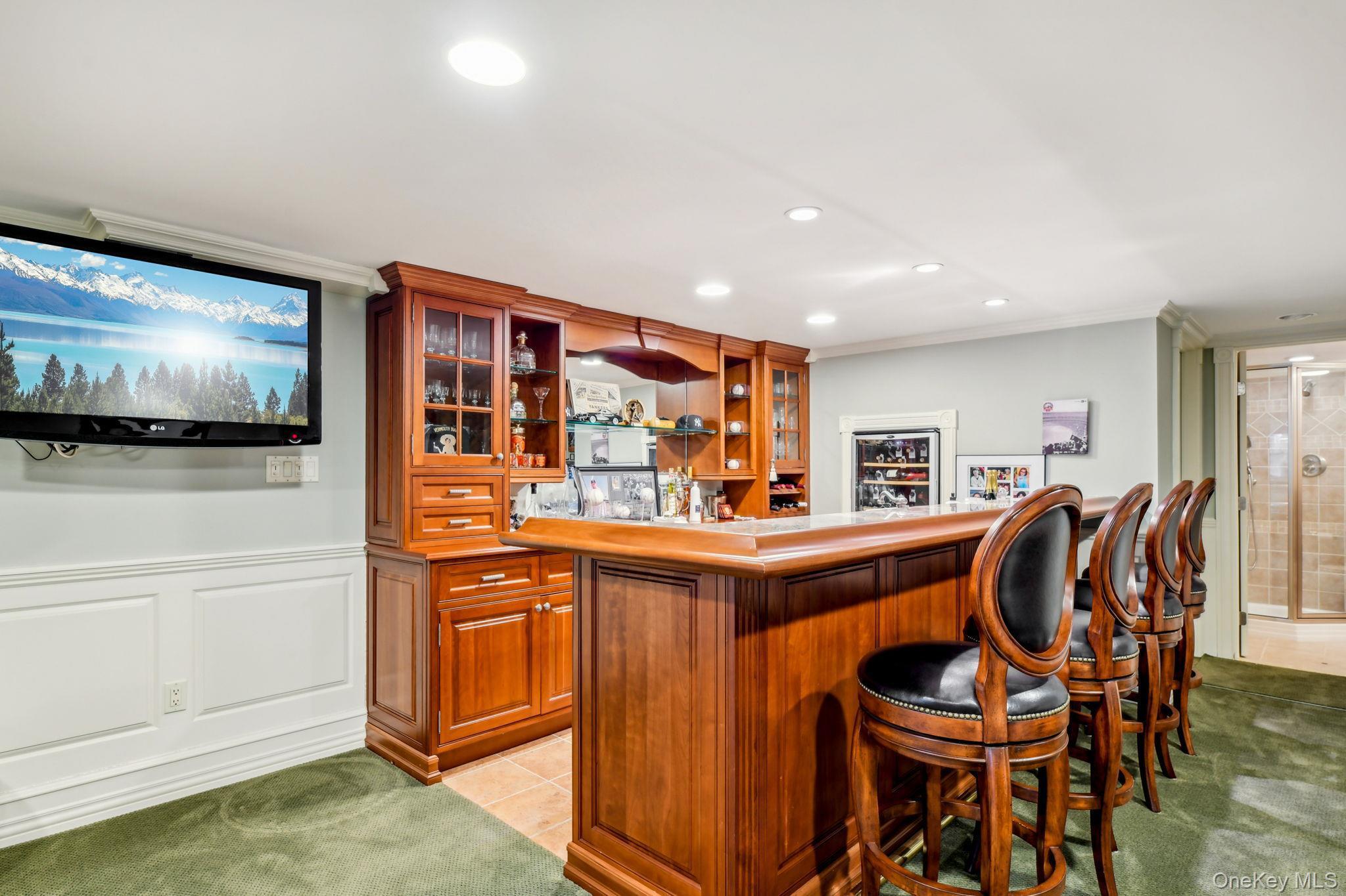 7 Short Path St. James, NY 11780 - Photo 12 of 17 Indoor bar with glass insert cabinets, crown molding, open shelves, brown cabinetry, and light countertops