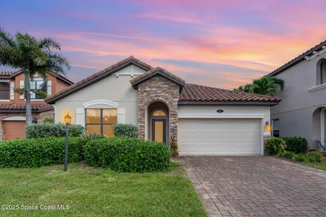 a front view of a house with a garden and garage
