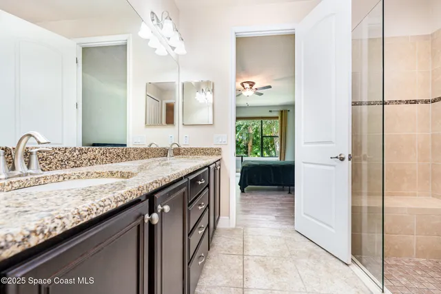 a bathroom with a granite countertop sink a mirror and a shower