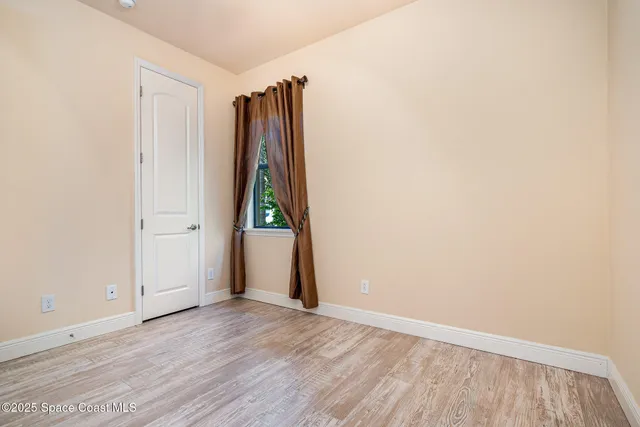 an empty room with wooden floor and a window
