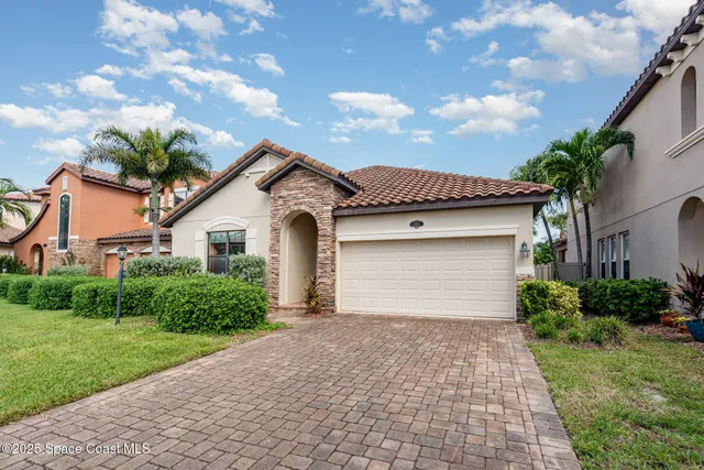 a front view of a house with a garden and plants
