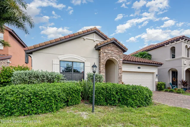 a view of house with garden and tall tree