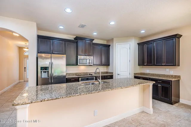a kitchen with stainless steel appliances granite countertop a stove a sink and a microwave