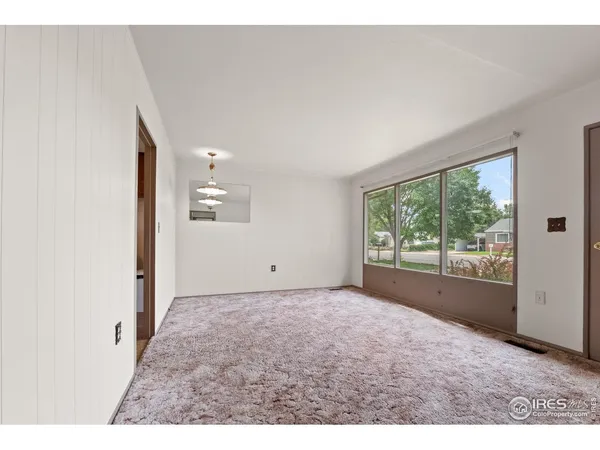 a view of a big room with wooden floor and windows