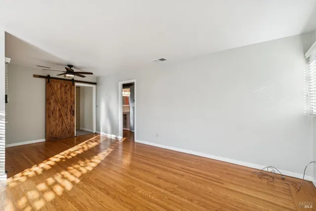 a view of empty room with wooden floor