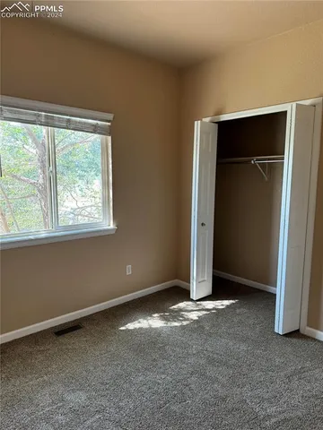 an empty room with closet and windows
