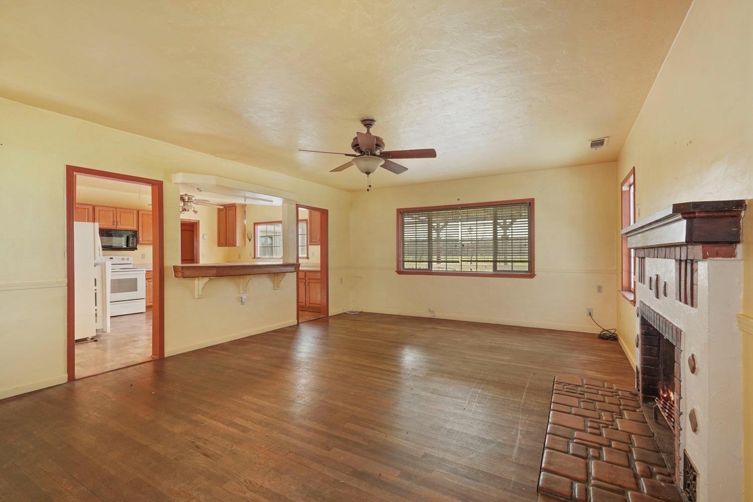 10710 North Shelton Road Linden, CA 95236 - Photo 36 of 75 an empty room with wooden floor a fireplace and windows