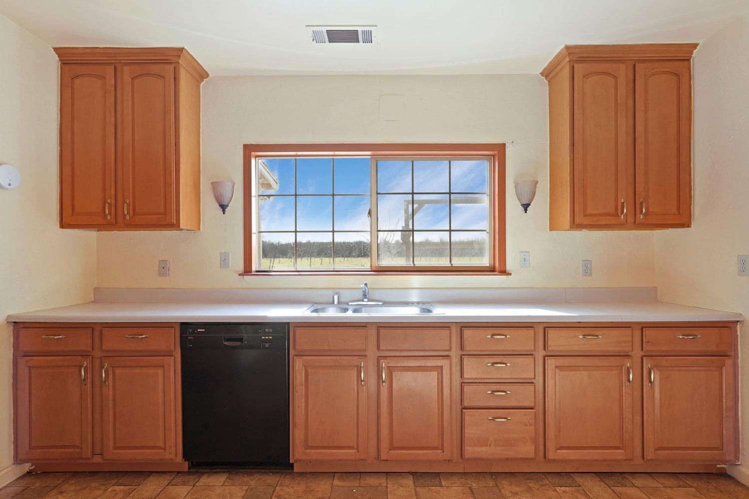 10710 North Shelton Road Linden, CA 95236 - Photo 42 of 75 a kitchen with granite countertop a sink cabinets and a wooden floor