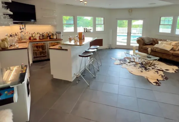 a living room with granite countertop couches a coffee table and a flat screen tv with kitchen view