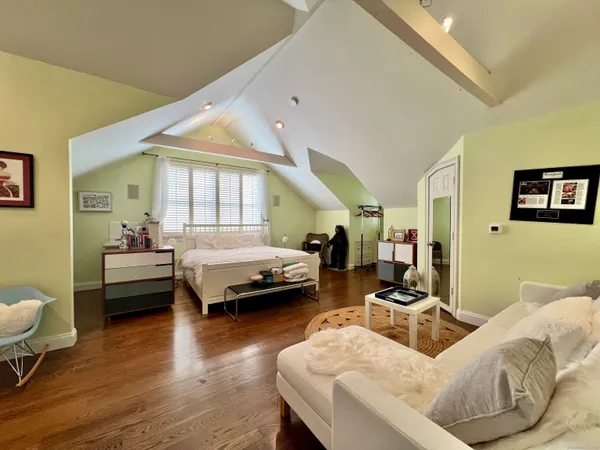 a bedroom with furniture and wooden floor