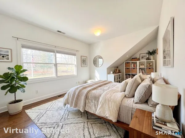 a bed sitting in a bedroom next to a window